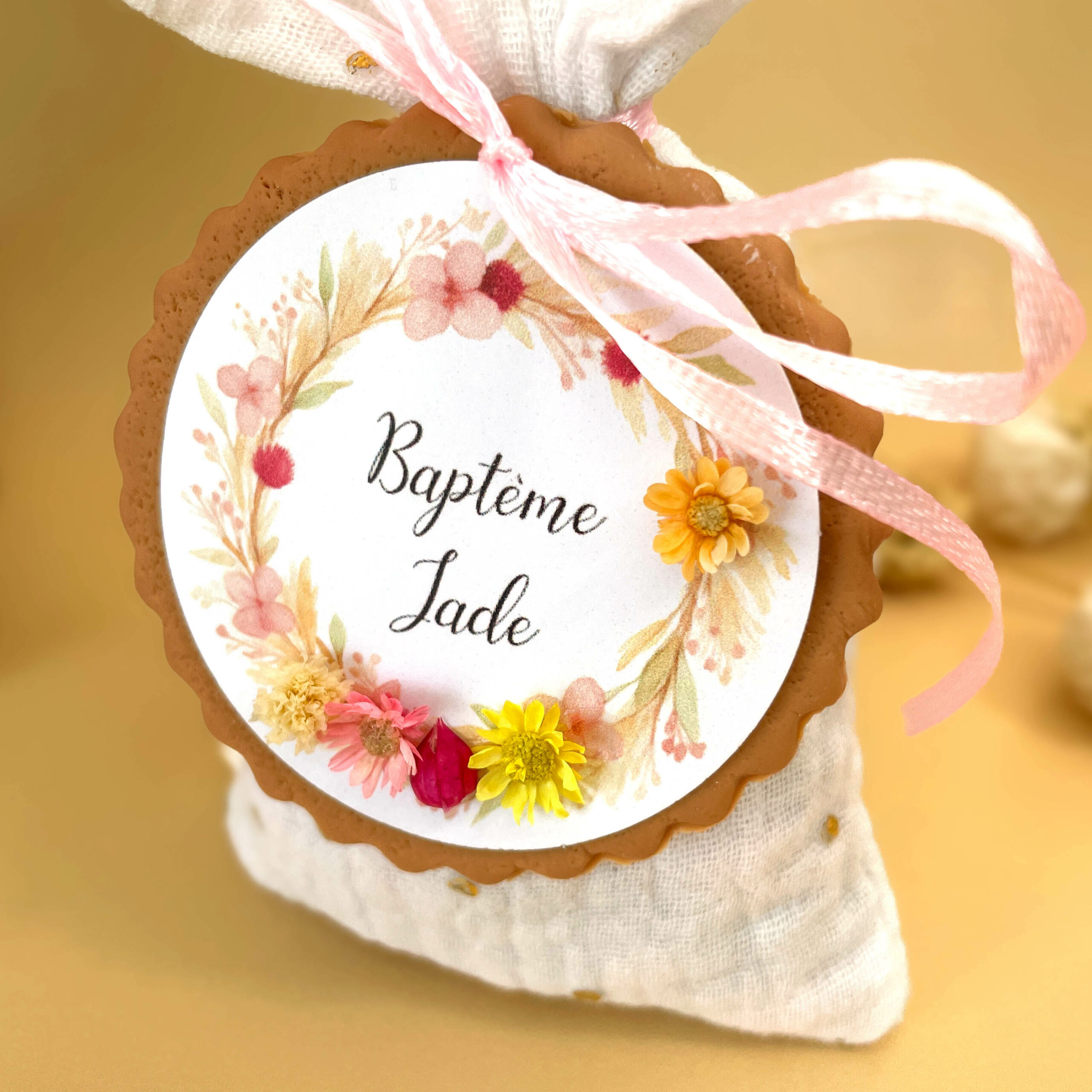 poncho-dragees-pour-bapteme-tissu-couleur-blanc-avec-couronne-fleur-sechees-rose-jaune-et-biscuit-personnalise